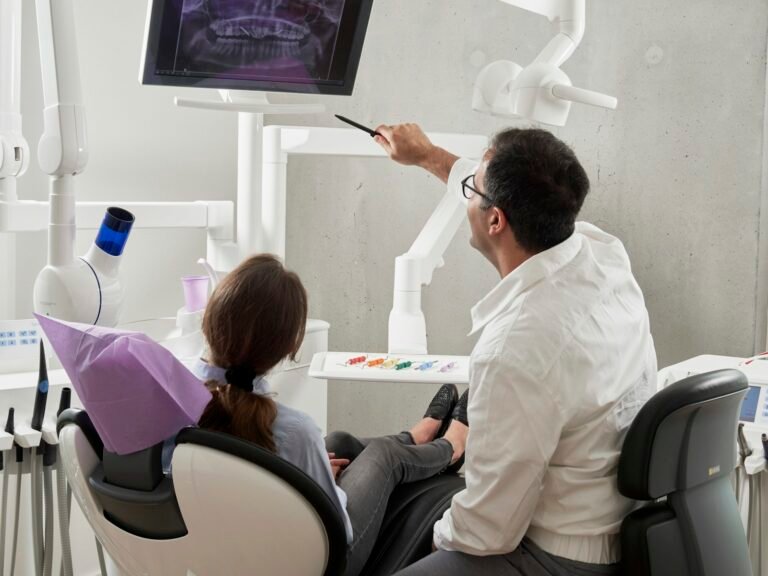 Dentist reviewing a panoramic X-ray with a patient — deciding between All-on-4 and All-on-6