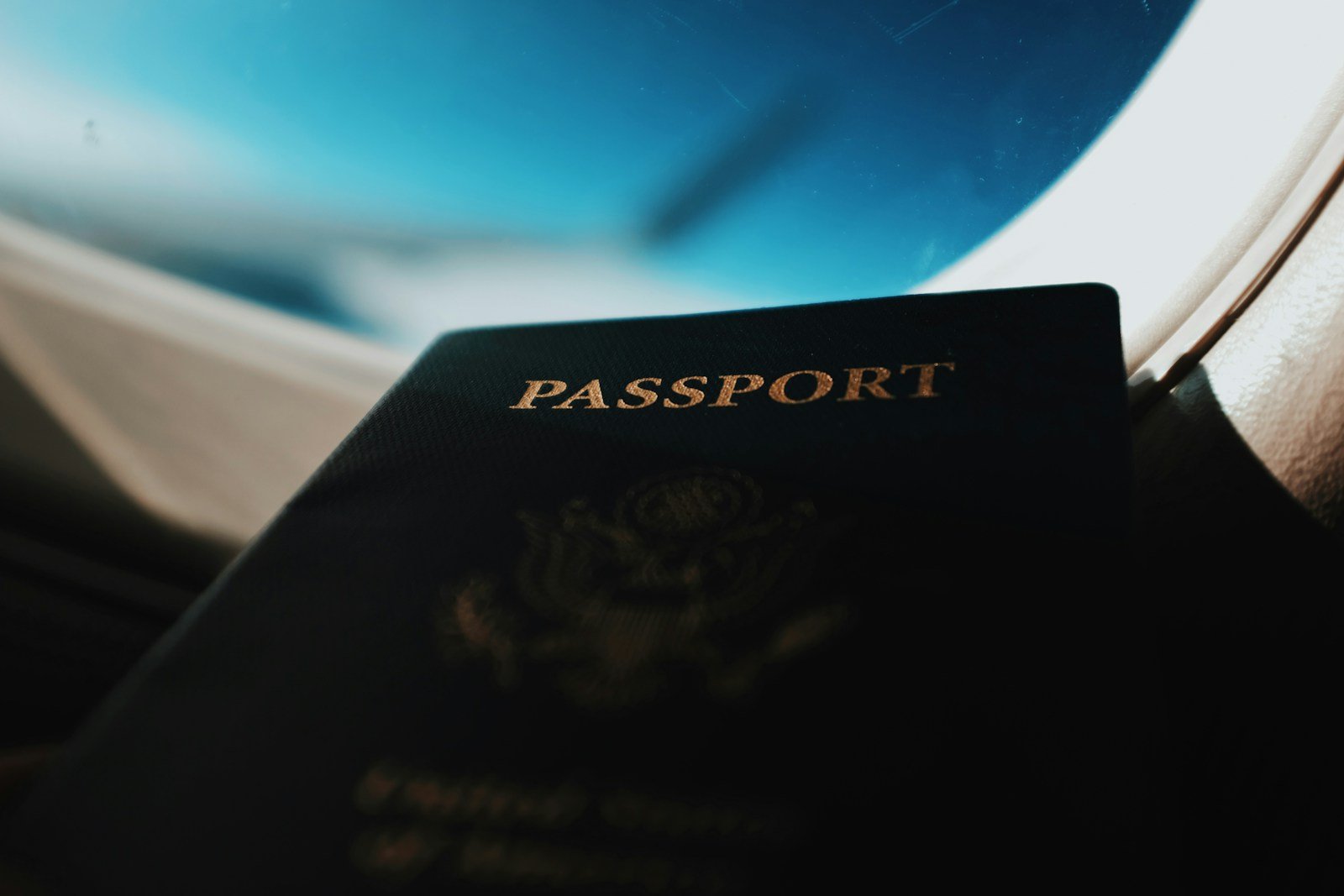 Passport held up in front of an aeroplane window